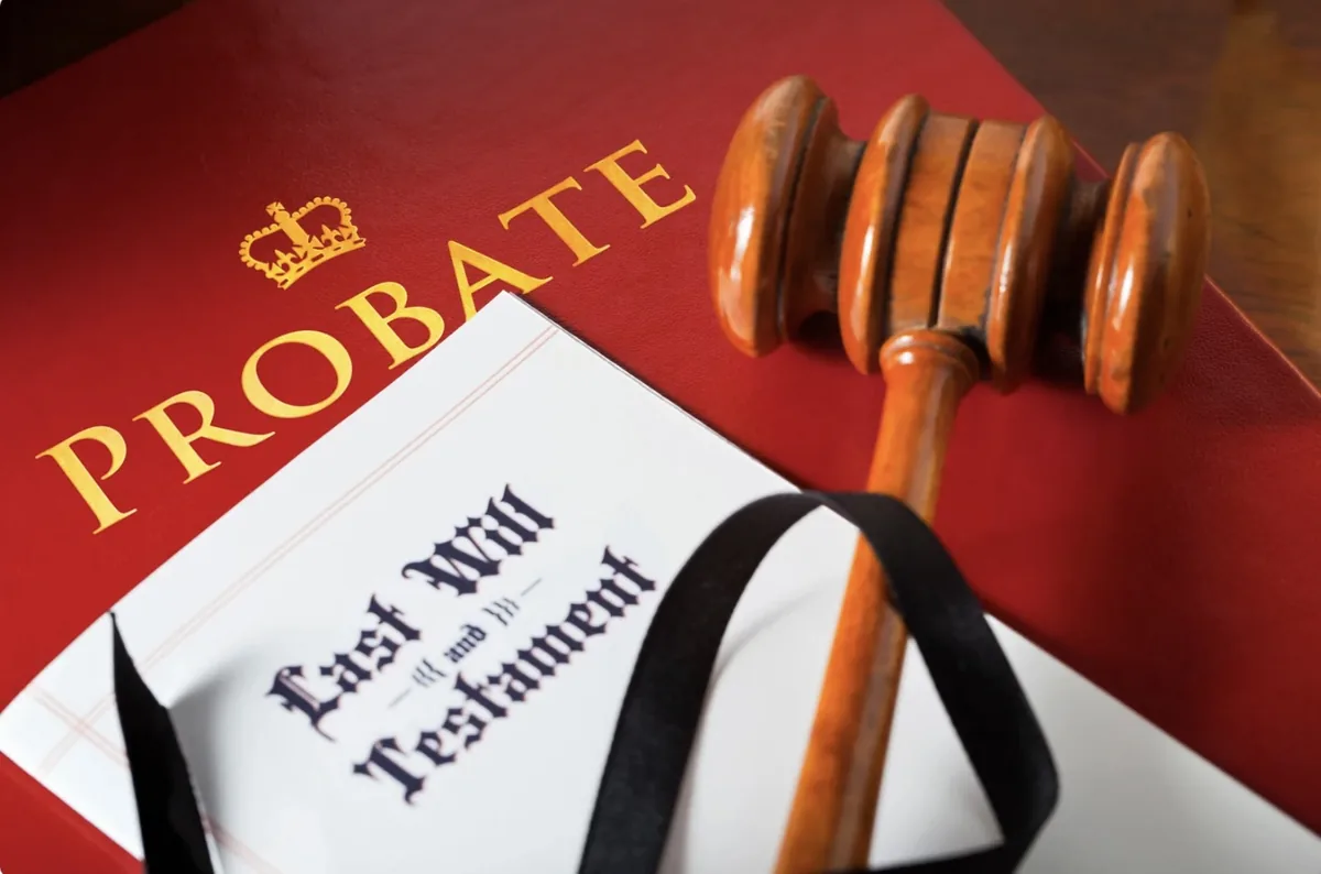A red leather Probate volume, a Last Will and Testament document, and a judge&rsquo;s gavel
